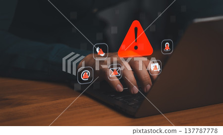 User at laptop with red warning icons and alert signs for cybersecurity, phishing threat, system error, and data protection concepts in dark workspace. User at laptop with red warning icons and alert signs for cybersecurity, phishing threat, system error, and data protection concepts in dark workspace. 137787778