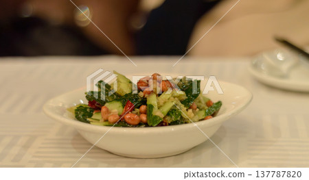 Cucumber salad with peanuts in a white bowl 137787820