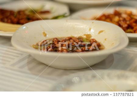 Spicy peanuts in chili oil in white bowl on restaurant table 137787821