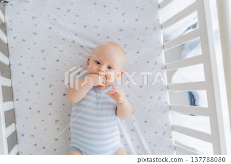 Baby lying peacefully in a cozy crib at home, feeling safe and calm in a warm nursery atmosphere. Simple everyday moment of care and comfort. Infant sleep, early childhood and gentle parenting concept Baby lying peacefully in a cozy crib at home, feeling safe and calm in a warm nursery atmosphere. Simple everyday moment of care and comfort. Infant sleep, early childhood and gentle parenting concept 137788080