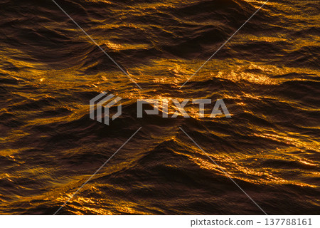 Close up view of the ocean undulating water colored by the setting sun in a dark metallic color with an orange tint, Tokyo, Japan Close up view of the ocean undulating water colored by the setting sun in a dark metallic color with an orange tint, Tokyo, Japan 137788161