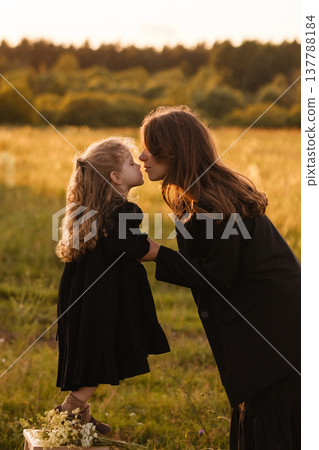 Mother And Daughter. Loving Mother And Daughter Share Tender Gesture In Bright Sunlit Meadow Mother And Daughter. Loving Mother And Daughter Share Tender Gesture In Bright Sunlit Meadow 137788184
