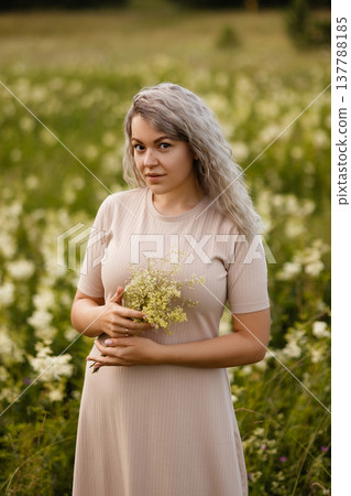 Woman Admiring Nature In Sunlight. Portrait Of Lady Surrounded By Blooming Wildflowers Outdoors Woman Admiring Nature In Sunlight. Portrait Of Lady Surrounded By Blooming Wildflowers Outdoors 137788185