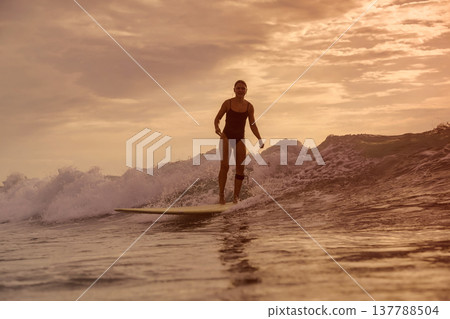 Relaxed Female Rider Gliding On Longboard At Sunset Over Gentle Waters Relaxed Female Rider Gliding On Longboard At Sunset Over Gentle Waters 137788504