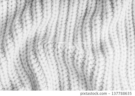 Crumpled white knitted fabric texture with folds, wrinkles and soft waves, wool background Crumpled white knitted fabric texture with folds, wrinkles and soft waves, wool background 137788635