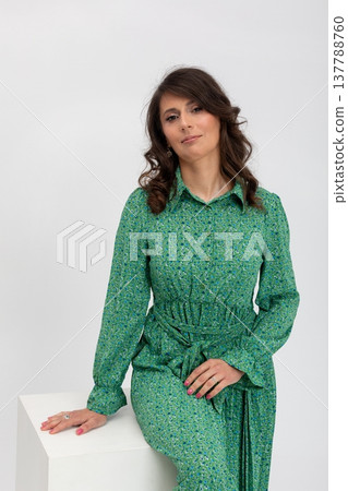 Elegant confident lady, Fashionable woman showcases style, Relaxed woman with curly hair exudes confidence, Stylish individual leaning on cube with calm demeanor and natural pose 137788760