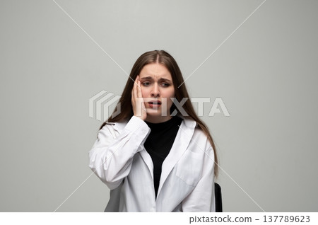Young woman experiencing stress and anxiety, suffering from a headache, feeling unwell, and needing relief Young woman experiencing stress and anxiety, suffering from a headache, feeling unwell, and needing relief 137789623