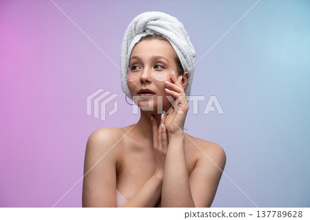 Young woman enjoying self-care routine with under-eye patches and bath towel, pampering her skin for a fresh, healthy, and revitalized beauty look 137789628