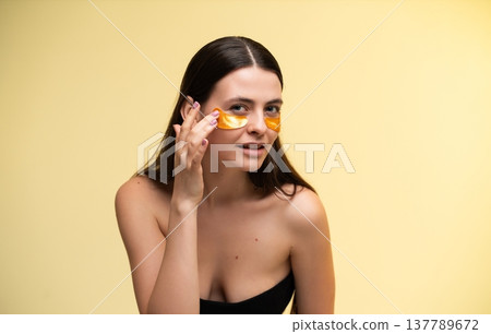 Young woman applying under eye patches for skincare and anti-aging hydration, getting beauty treatment and self-care for glowing, healthy skin, focusing on wellness routine Young woman applying under eye patches for skincare and anti-aging hydration, getting beauty treatment and self-care for glowing, healthy skin, focusing on wellness routine 137789672