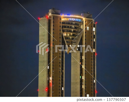 Modern Skyscraper With Glowing Outline, Tall Urban Structure Reflects Moody Sky And Illuminated Perimeter 137790307