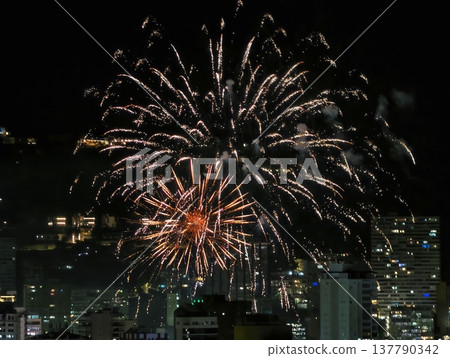 Colorful Explosion Illuminates Urban Skyline, Radiant Orange Burst Lights Up Night Sky Scene Colorful Explosion Illuminates Urban Skyline, Radiant Orange Burst Lights Up Night Sky Scene 137790342