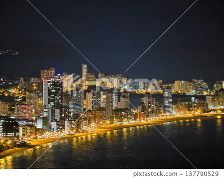 Nighttime Coastal Scenery Displays Radiant Lights Reflecting Urban Activity And Flowing Water 137790529