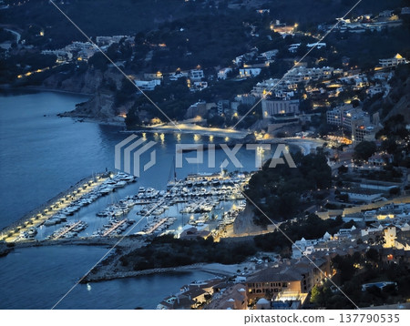 Evening Drive Along Shoreline With Glowing Lights And Peaceful Waters Creating Charming Scenery 137790535