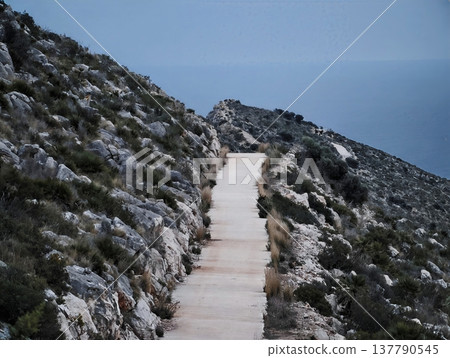 Quiet Coastal Mountain Trail Journey, Serene Ridge Route Descending With Rocky Banks And Distant Shore Quiet Coastal Mountain Trail Journey, Serene Ridge Route Descending With Rocky Banks And Distant Shore 137790545