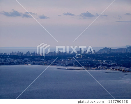 Coastal Towers Glow At Dusk, Urban Highrise Buildings Line Coast As Daylight Fades And Night Approaches 137790558