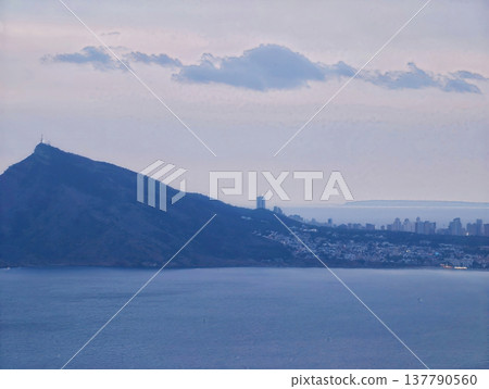 Cliffside Outlook Captures Bay And Urban Glow, Distant City And Bay Framed By Rugged Cliffs At Sunset Cliffside Outlook Captures Bay And Urban Glow, Distant City And Bay Framed By Rugged Cliffs At Sunset 137790560