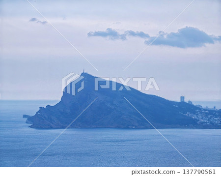 Secluded Coastal Outlook Features Serene Lighthouse Shining Over Gentle Waves And Distant Harbor 137790561