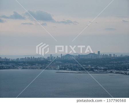 Dusk Water Scenery, Peaceful Seascape During Evening With Distant Urban Lights And Gently Rolling Water Dusk Water Scenery, Peaceful Seascape During Evening With Distant Urban Lights And Gently Rolling Water 137790568