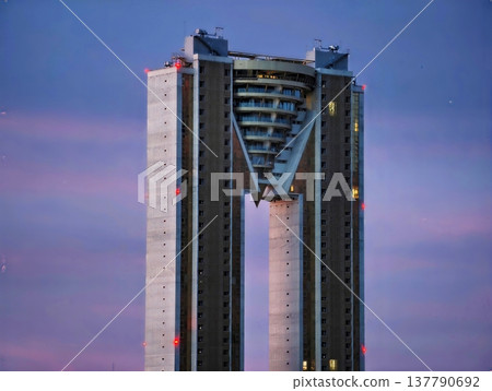 Elegant Skyscrapers With Vshaped Openings And Colorful Dusk Sky Creating Futuristic Urban Atmosphere Elegant Skyscrapers With Vshaped Openings And Colorful Dusk Sky Creating Futuristic Urban Atmosphere 137790692