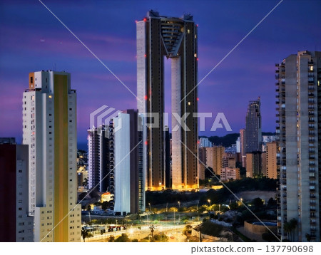 Illuminated City Skyline During Evening With Bustling Avenue And Reflective Glass Surfaces 137790698
