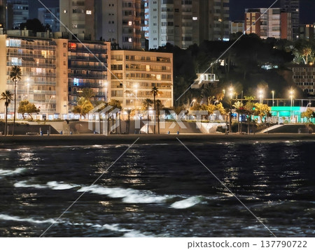 City Lights Reflecting On Water, Soft Sands And Shimmering Lights Craft Mysterious Shoreline Atmosphere 137790722