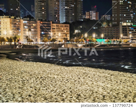 Textured Beach Front Leading To Glowing Cityscape With Ocean Waves And Silhouettes Of Towers Textured Beach Front Leading To Glowing Cityscape With Ocean Waves And Silhouettes Of Towers 137790724