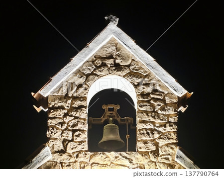 Bright Church Tower, Radiant Bell Tower Silhouette Sharply Contrasts With Dark Sky And Village Background 137790764