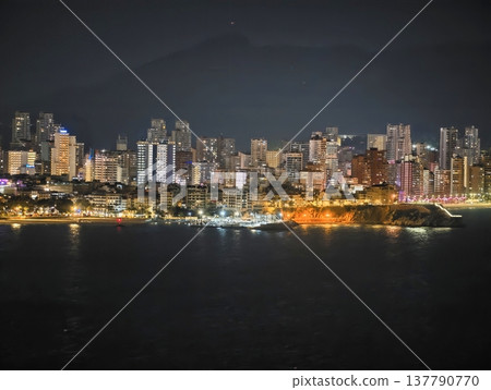 Silent Coastal Horizon With Shimmering Reflections And Layered Lights Enhancing Peaceful Nighttime Atmosphere 137790770