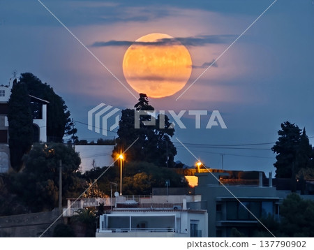 Night Scene With Glowing Moon, Coastal Rooftops Illuminated By Large Moon And Streetlamp Shadows Night Scene With Glowing Moon, Coastal Rooftops Illuminated By Large Moon And Streetlamp Shadows 137790902