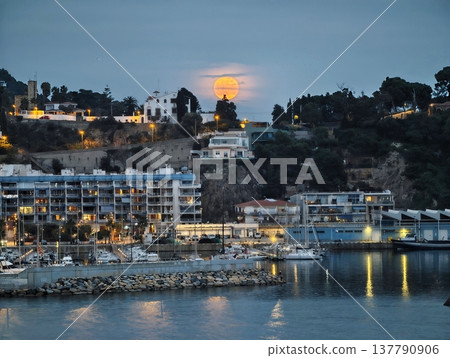 Night Falls Over Harbor, Moon Ascends Behind Seaside Village With Shimmering Water And Boats Night Falls Over Harbor, Moon Ascends Behind Seaside Village With Shimmering Water And Boats 137790906