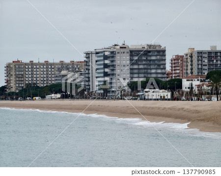 Relaxed Coastal Landscape With Apartment Complexes Along Calm Waters And Overcast Sky Reaching Distant Horizon Relaxed Coastal Landscape With Apartment Complexes Along Calm Waters And Overcast Sky Reaching Distant Horizon 137790985