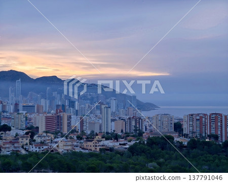 City Evening Panorama, Sunset Over Mountain Cityscape, Calm City Skyline With Glowing Waterfront Buildings 137791046