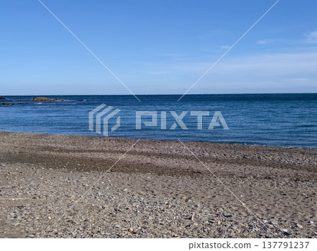 Pebble Beach With Calm Blue Sea, Gentle Waves, Clear Sky, Empty Shoreline, Morning Light 137791237