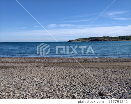 Minimalist Blue Horizon With Calm Ocean, Smooth Water, Faint Clouds, Pebble Foreground 137791241