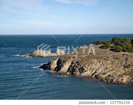 Marine Landscape Showcasing Lighthouse On Rugged Coast With Breaking Waves And Sunlit Rocky Outcrop 137791250