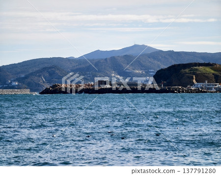 Calm Sea With Island Silhouette, Serene Ocean View Displaying Rugged Coast And Distant Mountains Calm Sea With Island Silhouette, Serene Ocean View Displaying Rugged Coast And Distant Mountains 137791280