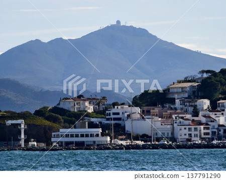 Coastal Community Nestled Beneath High Summit, Littoral Hamlet With Towering Mountains And Lush Slopes Coastal Community Nestled Beneath High Summit, Littoral Hamlet With Towering Mountains And Lush Slopes 137791290