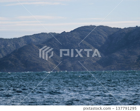Rough Peaks Confront Turbulent Ocean Waves, Jagged Mountains Overlook Chaotic Waters Beneath Muted Sky Rough Peaks Confront Turbulent Ocean Waves, Jagged Mountains Overlook Chaotic Waters Beneath Muted Sky 137791295