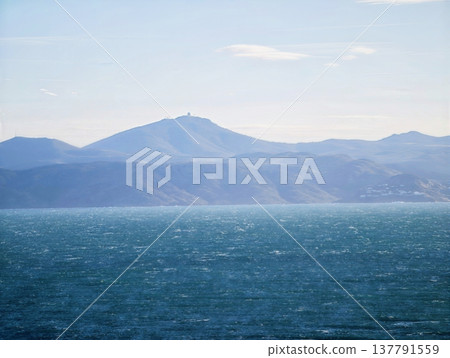 Tranquil Coastal Landscape For Relaxation, Peaceful Oceanfront With Mountains Under Bright Sky Tranquil Coastal Landscape For Relaxation, Peaceful Oceanfront With Mountains Under Bright Sky 137791559