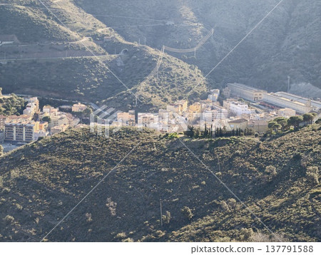 Secluded Village Nestled In Valleys, Distant Hillside Town Hidden Among Rolling Earth And Rocky Slopes 137791588