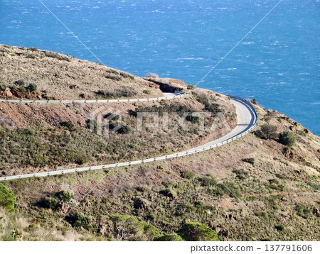 Serene Seaside Trail With Ocean Views, Curving Cliff Path Along Shimmering Blue Water Coastline Serene Seaside Trail With Ocean Views, Curving Cliff Path Along Shimmering Blue Water Coastline 137791606