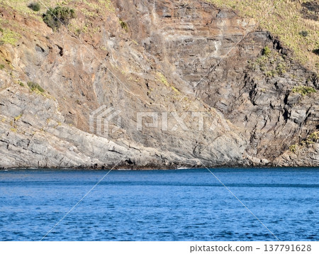 Idyllic Bay Highlights Evident Stratification Of Rocks Through Transparent Waters Bathed In Bright Sunlight Idyllic Bay Highlights Evident Stratification Of Rocks Through Transparent Waters Bathed In Bright Sunlight 137791628