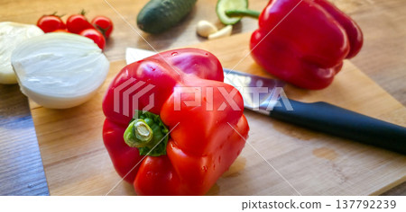 Fresh vegetables: peppers, cucumbers, onions, tomatoes, and garlic on a cutting board with a knife. Healthy dietary nutrition. Consumption of vegetables in the diet. High quality photo Fresh vegetables: peppers, cucumbers, onions, tomatoes, and garlic on a cutting board with a knife. Healthy dietary nutrition. Consumption of vegetables in the diet. High quality photo 137792239
