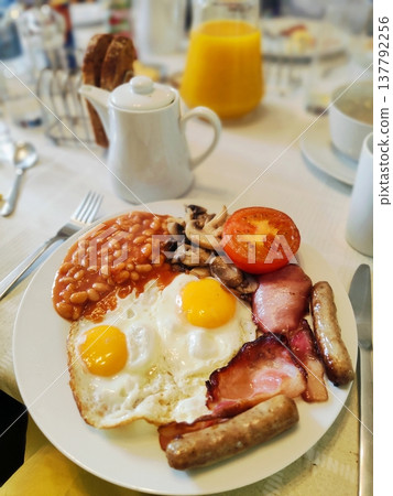 A classic full English breakfast with scrambled eggs, bacon, beans and sausages 137792256