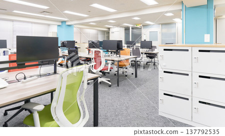 A corporate office workspace lined with computers. 137792535