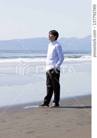 A man walking along the beach A man walking along the beach 137792560