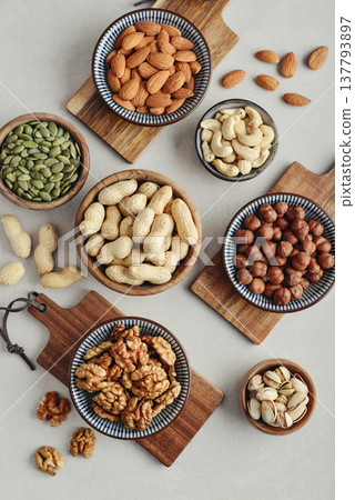 Walnuts, cashews, almonds, hazelnuts, peanuts, pistachios and pumpkin seeds in plates 137793897