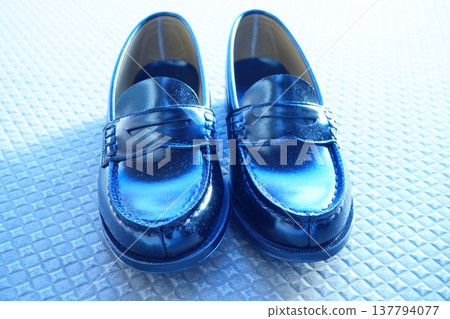 A row of black loafers lined up from the front. A simple shoe photograph evoking images of commuting to school or student life. A row of black loafers lined up from the front. A simple shoe photograph evoking images of commuting to school or student life. 137794077