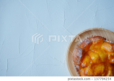 A close-up of sweet bread served on a wooden plate. A food photograph evoking breakfast or café time. A close-up of sweet bread served on a wooden plate. A food photograph evoking breakfast or café time. 137794254