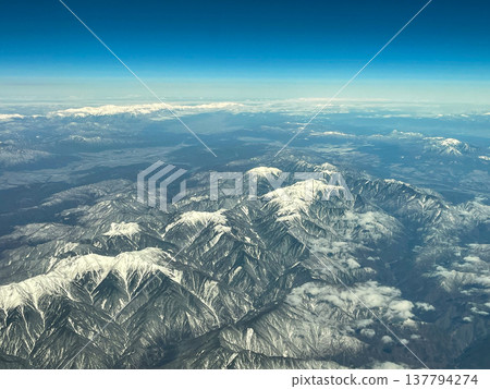 View of the Southern Alps, Central Alps, and Iida city from inside the aircraft. View of the Southern Alps, Central Alps, and Iida city from inside the aircraft. 137794274